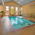 magnificen-small-indoor-swimming-pool-with-gorgeous-blue-tile-base-and-magnifceint-brick-wall-and-grabiet-paving-with-exquisite-armchair-for-class-house-style